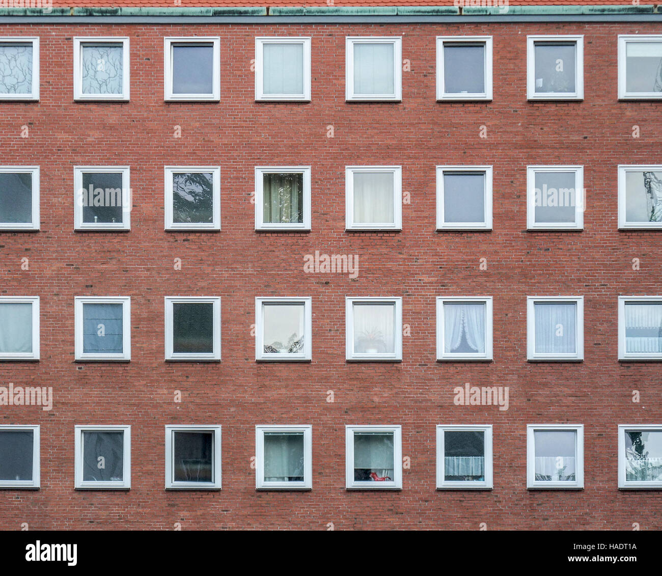 Générique d'une façade de maison faite de briques rouges avec un grand nombre de fenêtres Banque D'Images