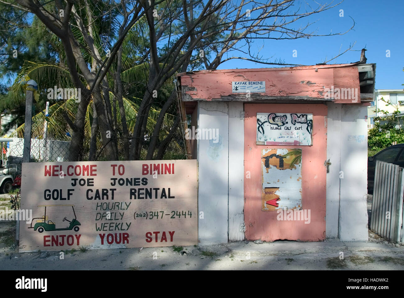 Services touristiques publicité signes sur un vieux bâtiment le long de la route du Roi à Alice Town sur la petite île des Caraïbes de Bimini, Bahamas Banque D'Images