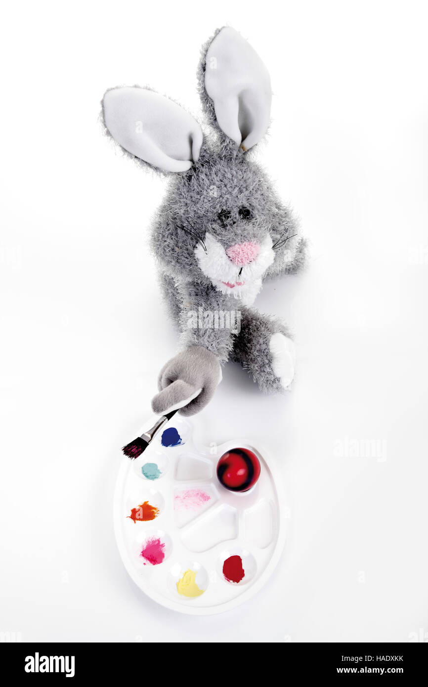 Doudou lapin de Pâques avec palette de couleurs, pinceau et d'un oeuf de  Pâques colorés Photo Stock - Alamy