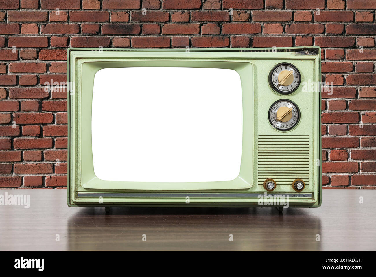 Grungy green vintage téléviseur avec mur de brique et découper l'écran. Banque D'Images