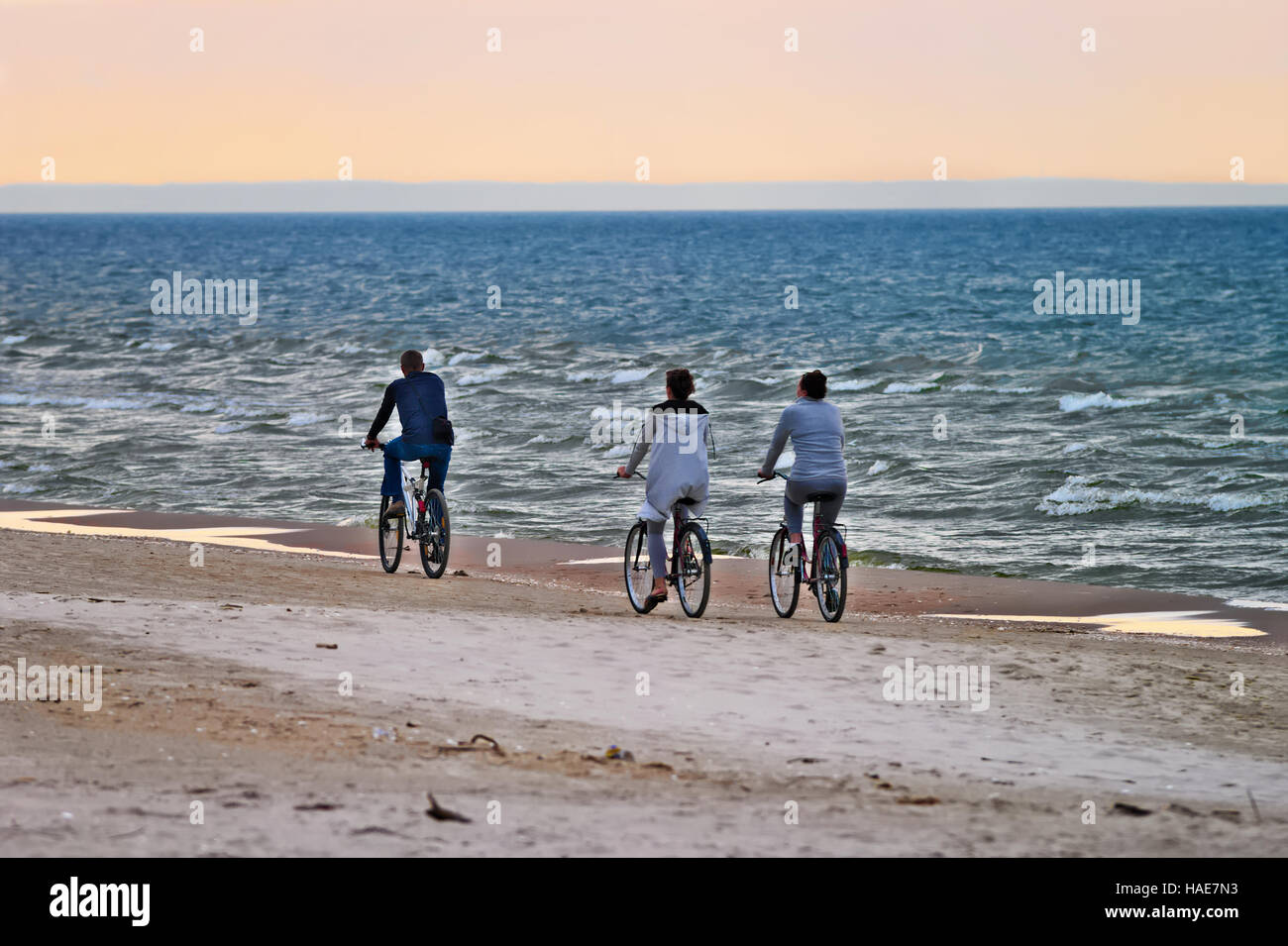 Groupe de cyclistes sur la plage la bicyclette le long de la mer dans la soirée. Focus sélectif. Stegna, Poméranie, Pologne. Banque D'Images