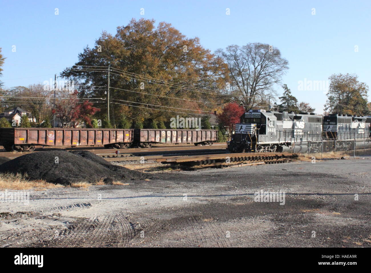 Train noir en face de tas de charbon. Banque D'Images