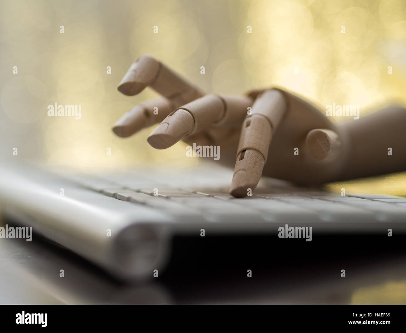 Simulacre en bois main sur le clavier d'un ordinateur. Banque D'Images