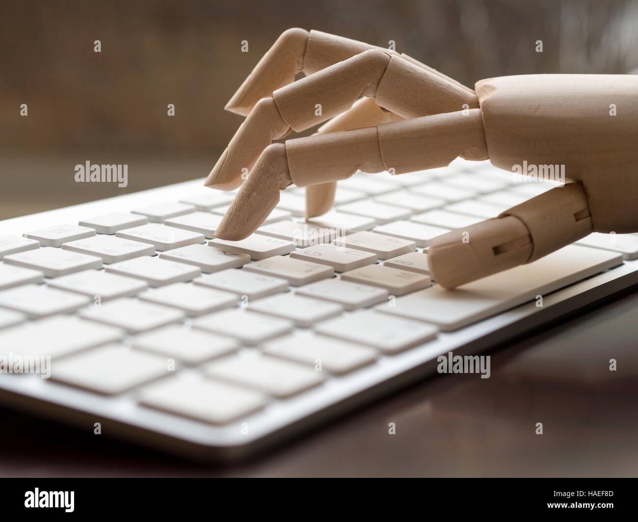 Simulacre en bois main sur le clavier d'un ordinateur. Banque D'Images