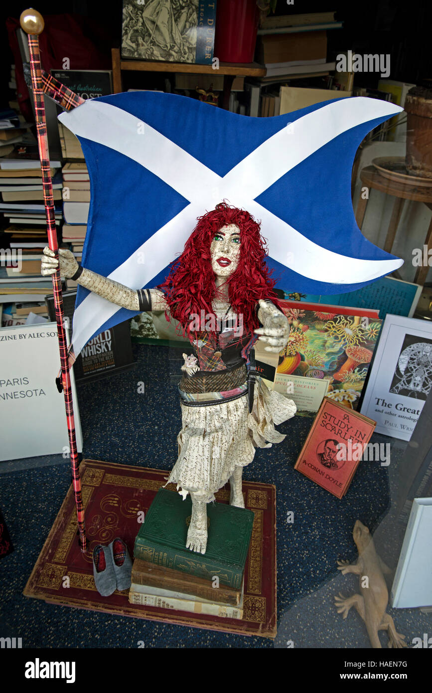Une figure faite à partir de vieux livres montrant une femme à tête rouge tenant le sautoir dans la fenêtre d'une librairie d'occasion à Edimbourg. Banque D'Images