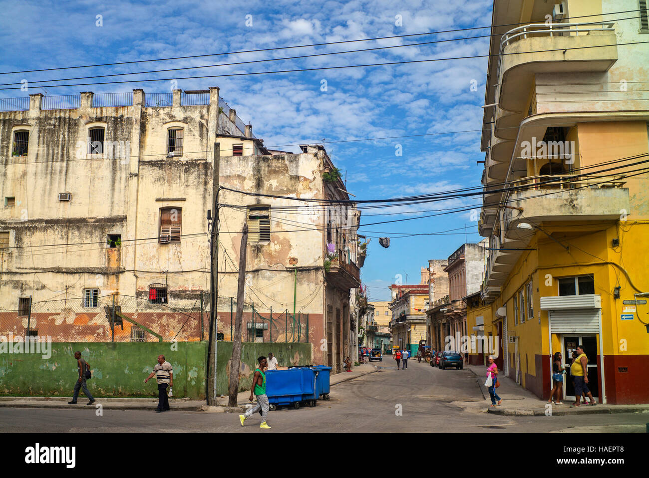Havana Street corner view apartment block et rue avec mur vert de terrain de sport surmonté d'un grillage de sécurité dans le centre de La Havane Banque D'Images