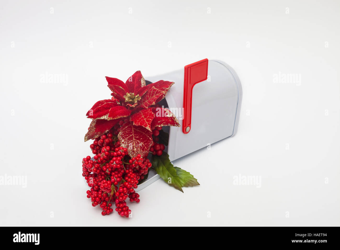 Poinsettia artificiel et baies rouges dans une boîte aux lettres avec le drapeau Banque D'Images
