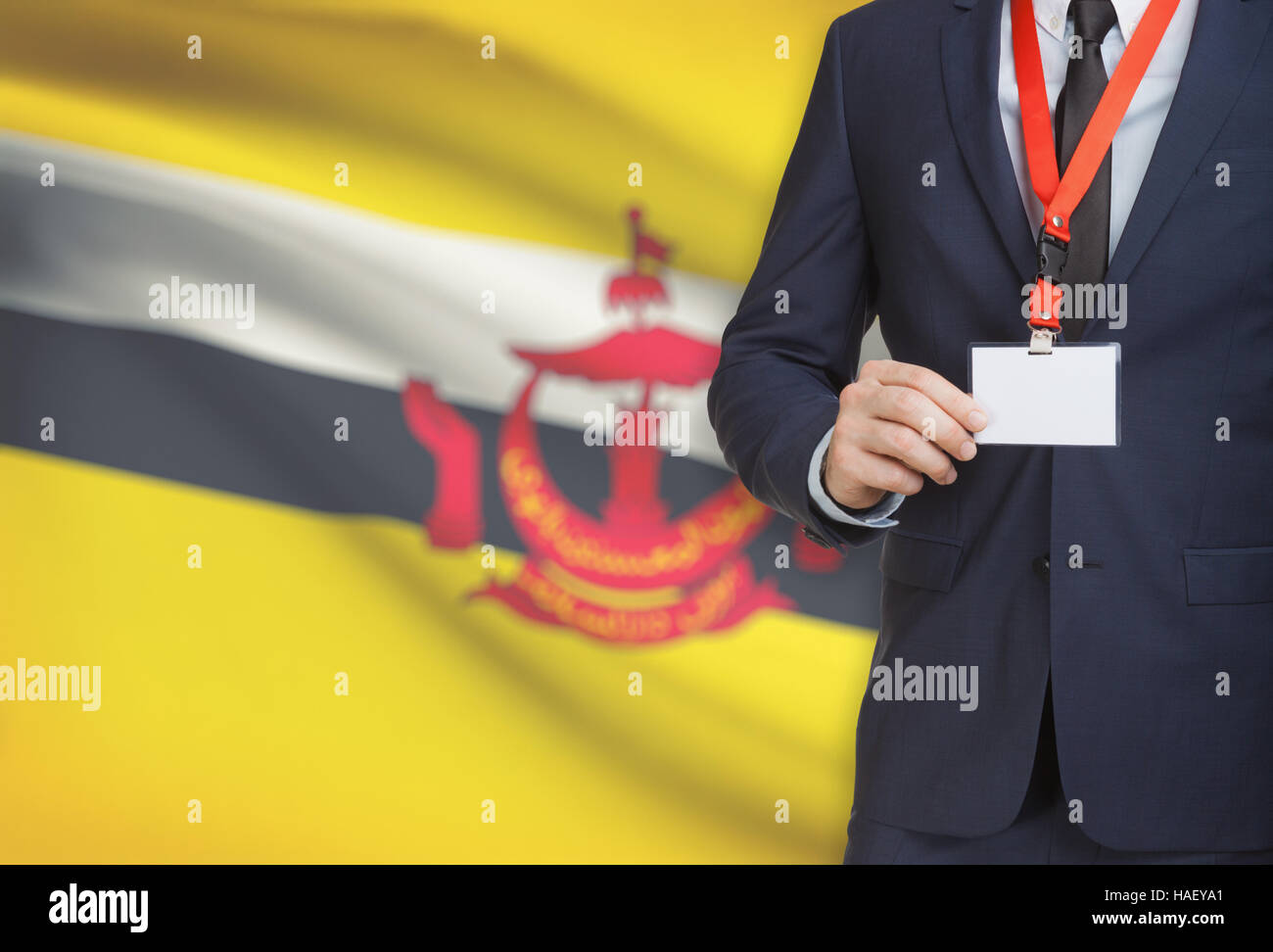 Businessman holding name badge carte sur un cordon avec un drapeau sur le fond - Brunei Banque D'Images