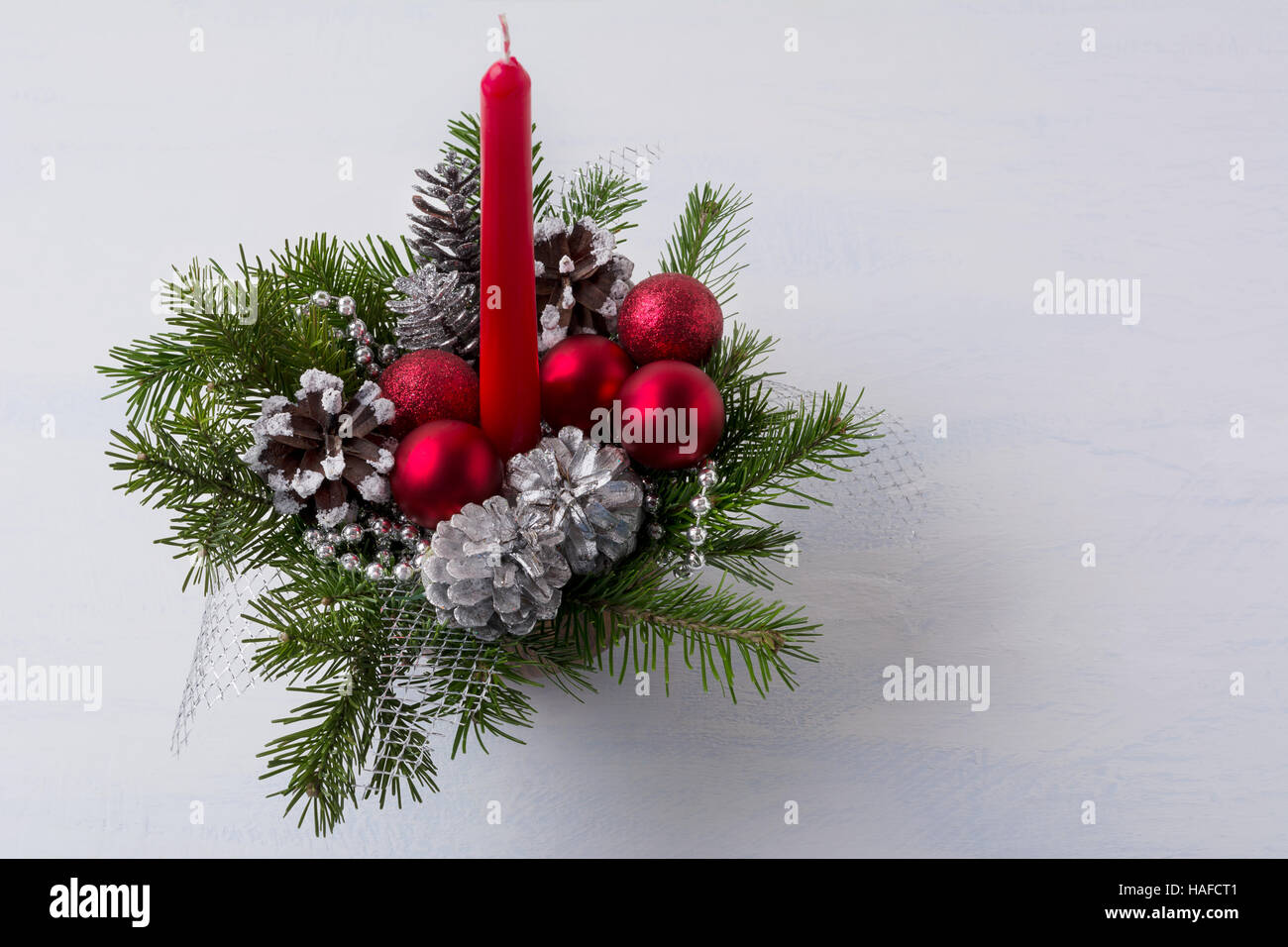 Centre de table de Noël avec bougie rouge et pommes de pin d'argent. Fond de Noël avec des ornements rouges. Copier l'espace. Banque D'Images