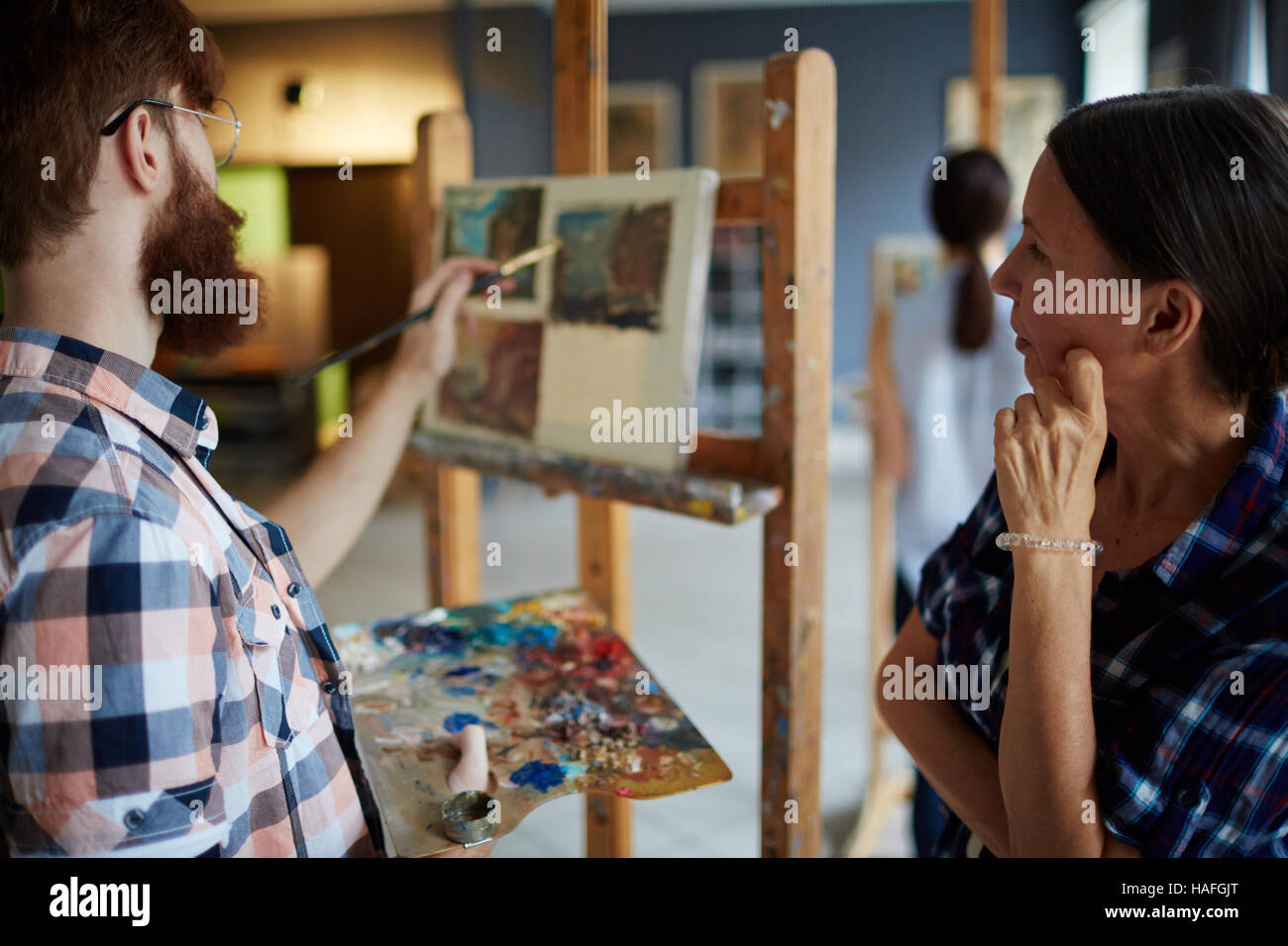 Enseignant à la peinture à la maturité de l'un de ses étudiants en art-studio Banque D'Images
