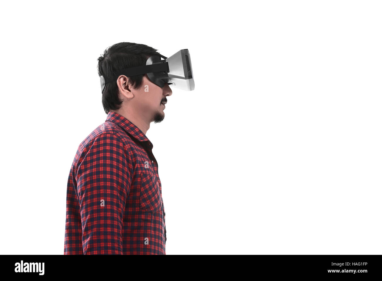 Young Asian man en réalité virtuelle à travers un casque VR isolé sur fond blanc Banque D'Images