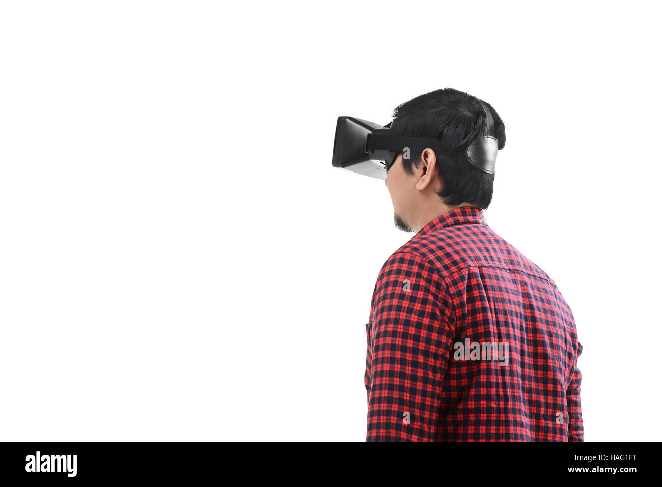 Young Asian man en réalité virtuelle à travers un casque VR isolé sur fond blanc Banque D'Images