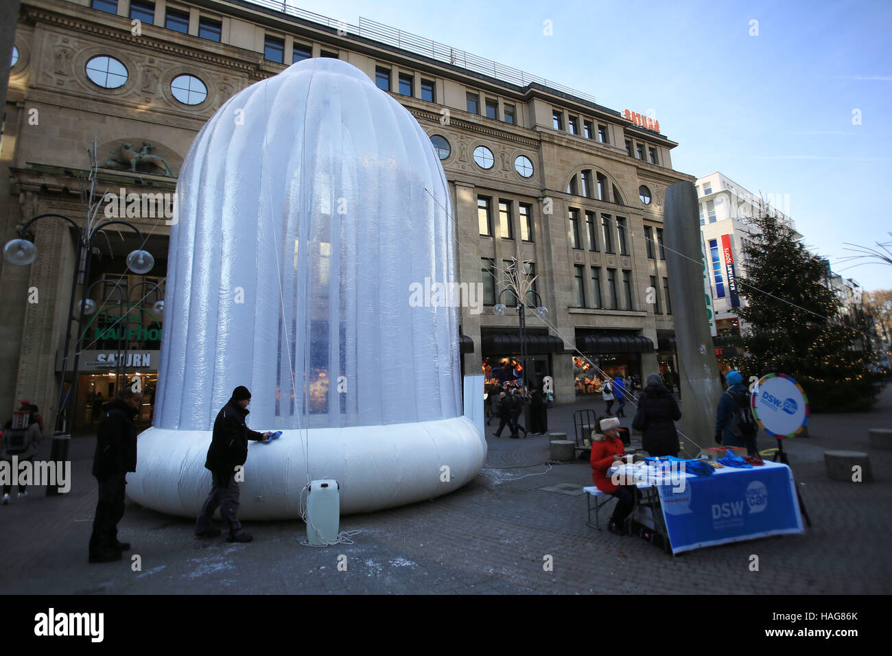 Cologne, Allemagne. 30Th Nov, 2016. Les piétons circulant au-delà d'un préservatif gonflable, de plusieurs mètres de haut, à Cologne, Allemagne, 30 novembre 2016. Une organisation de développement veut faire prendre conscience de l'infection à VIH risque sur la journée mondiale contre le SIDA. Photo : Oliver Berg/dpa/Alamy Live News Banque D'Images