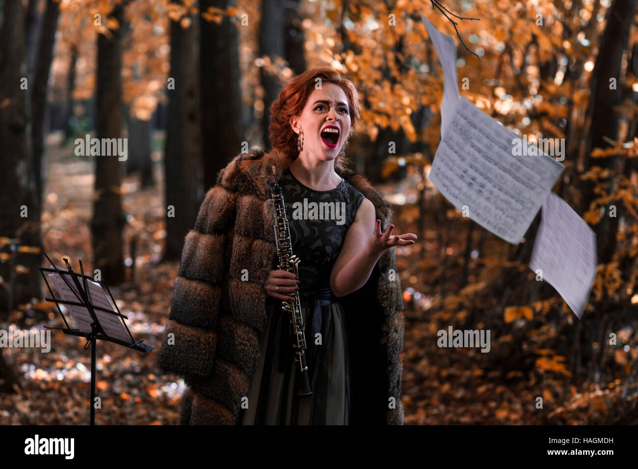 Jeune femme émotionnelle jeter les feuilles de musique et la tenue d'un hautbois dans la main Banque D'Images