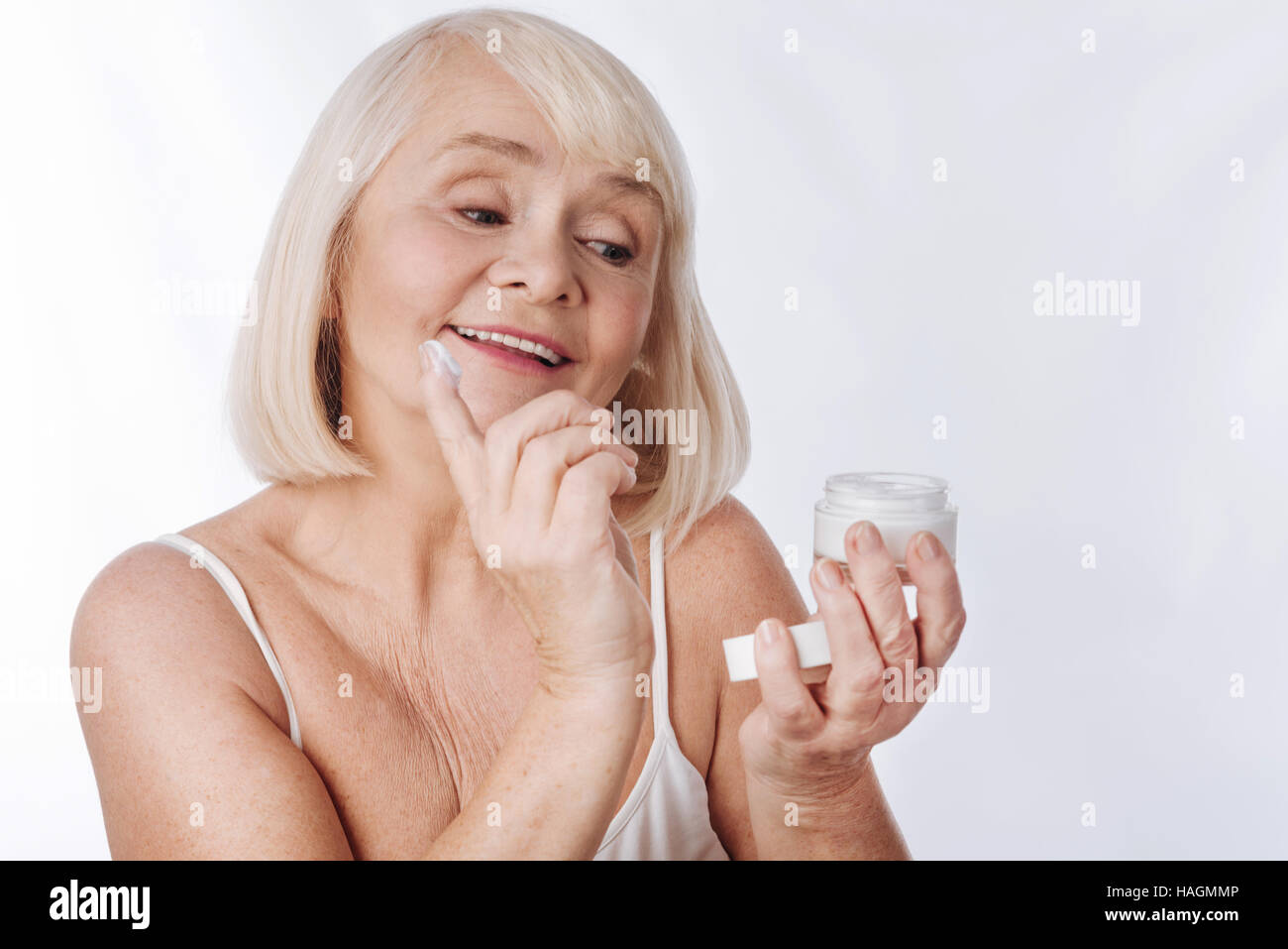 Bonne, à la femme de mettre de la crème anti age Banque D'Images