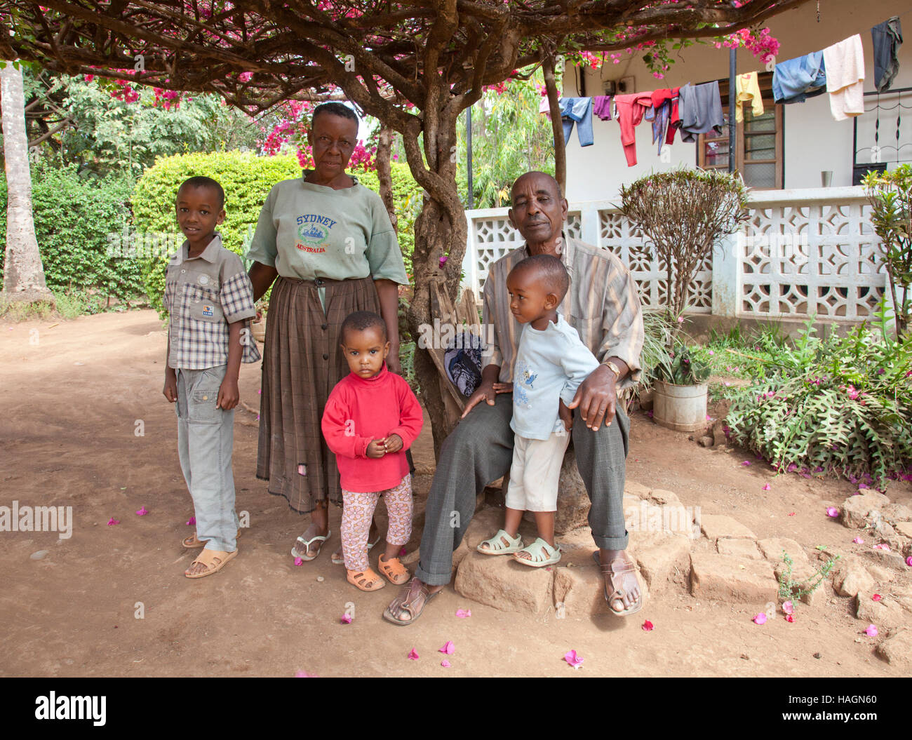 La famille africaine en Tanzanie devant leur maison dans les zones rurales de Tanzanie, l'Afrique à jouer et travailler en s'amusant Banque D'Images