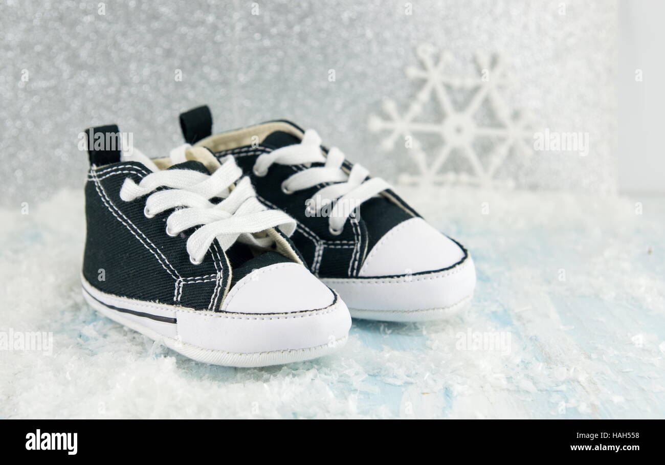 Paire de chaussures de bébé noir dans la neige Banque D'Images