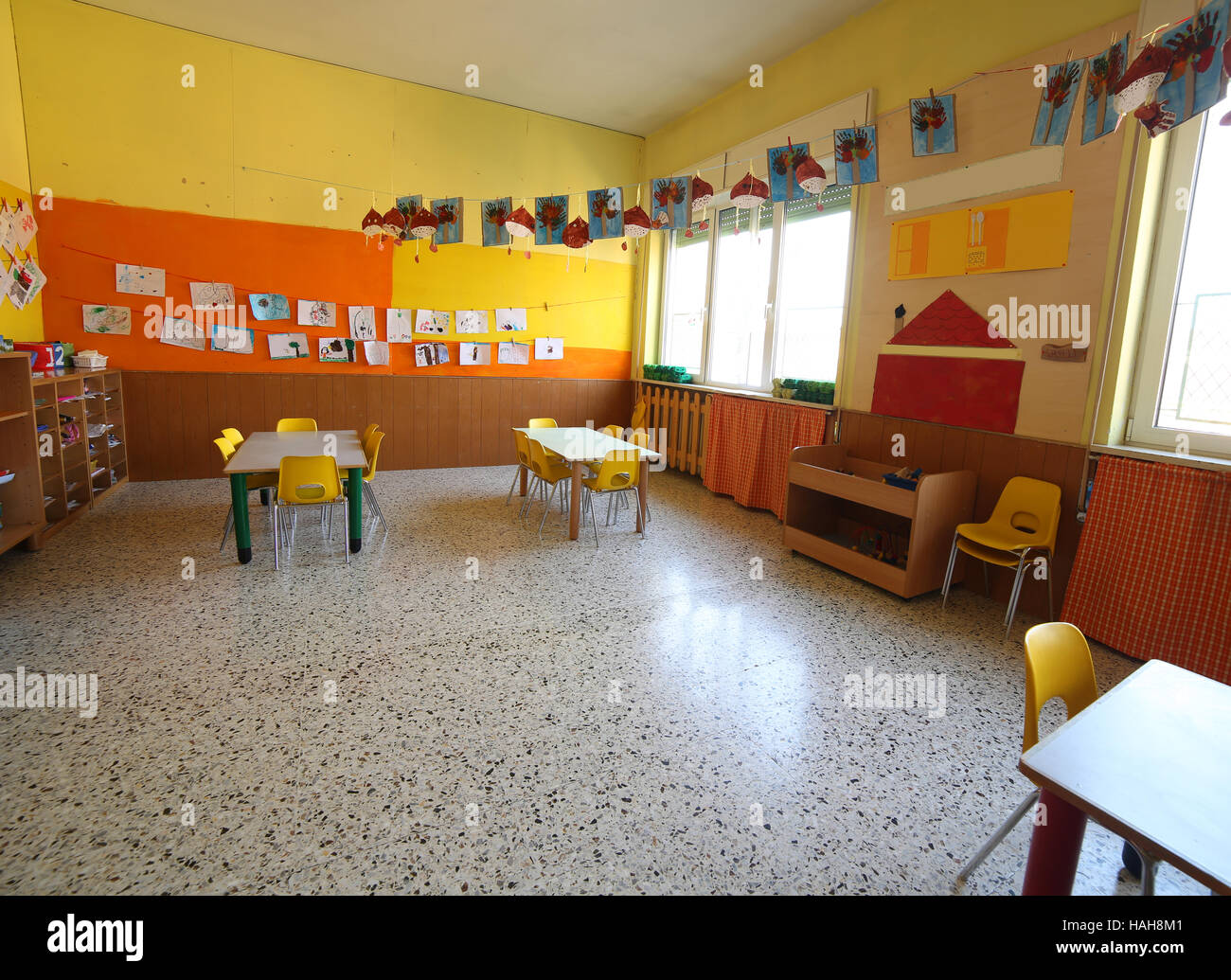 Classe d'une pépinière de la petite enfance avec les dessins et les tables et petites chaises Banque D'Images