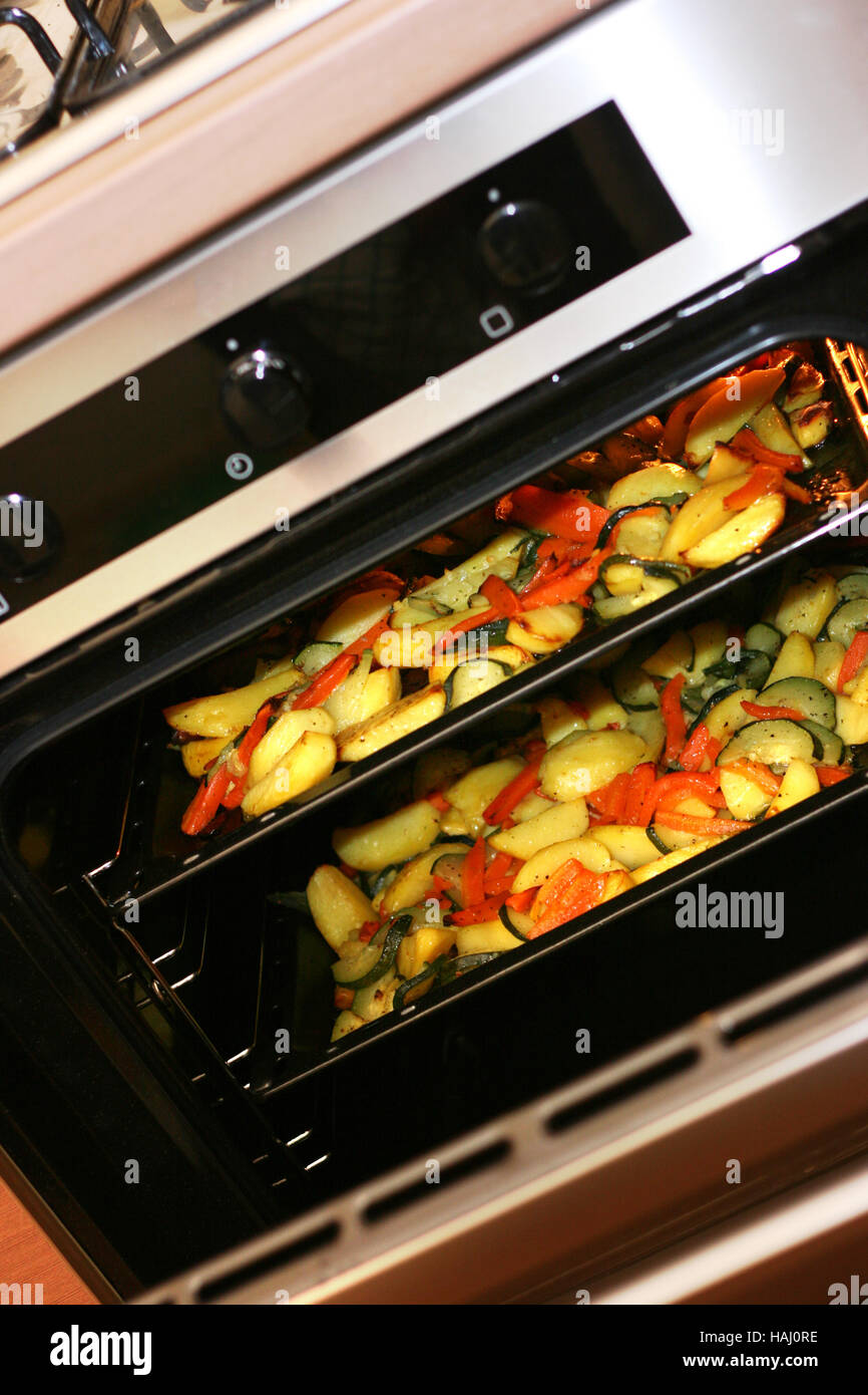 Les légumes et pommes de terre au four dans un four Banque D'Images
