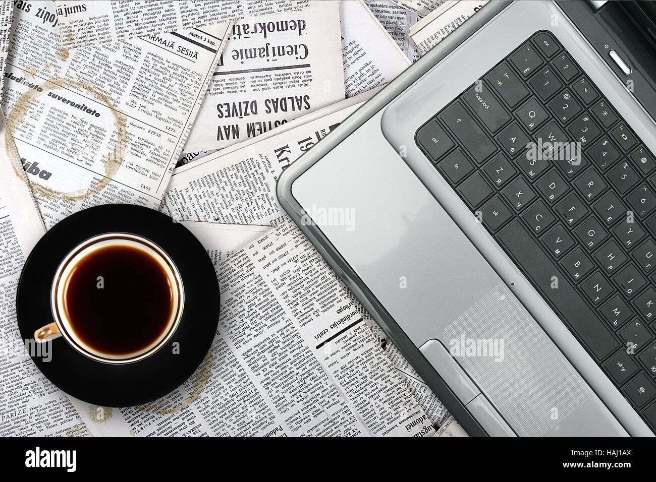 Lieu de travail avec ordinateur portable et tasse de café sur fond de journal Banque D'Images