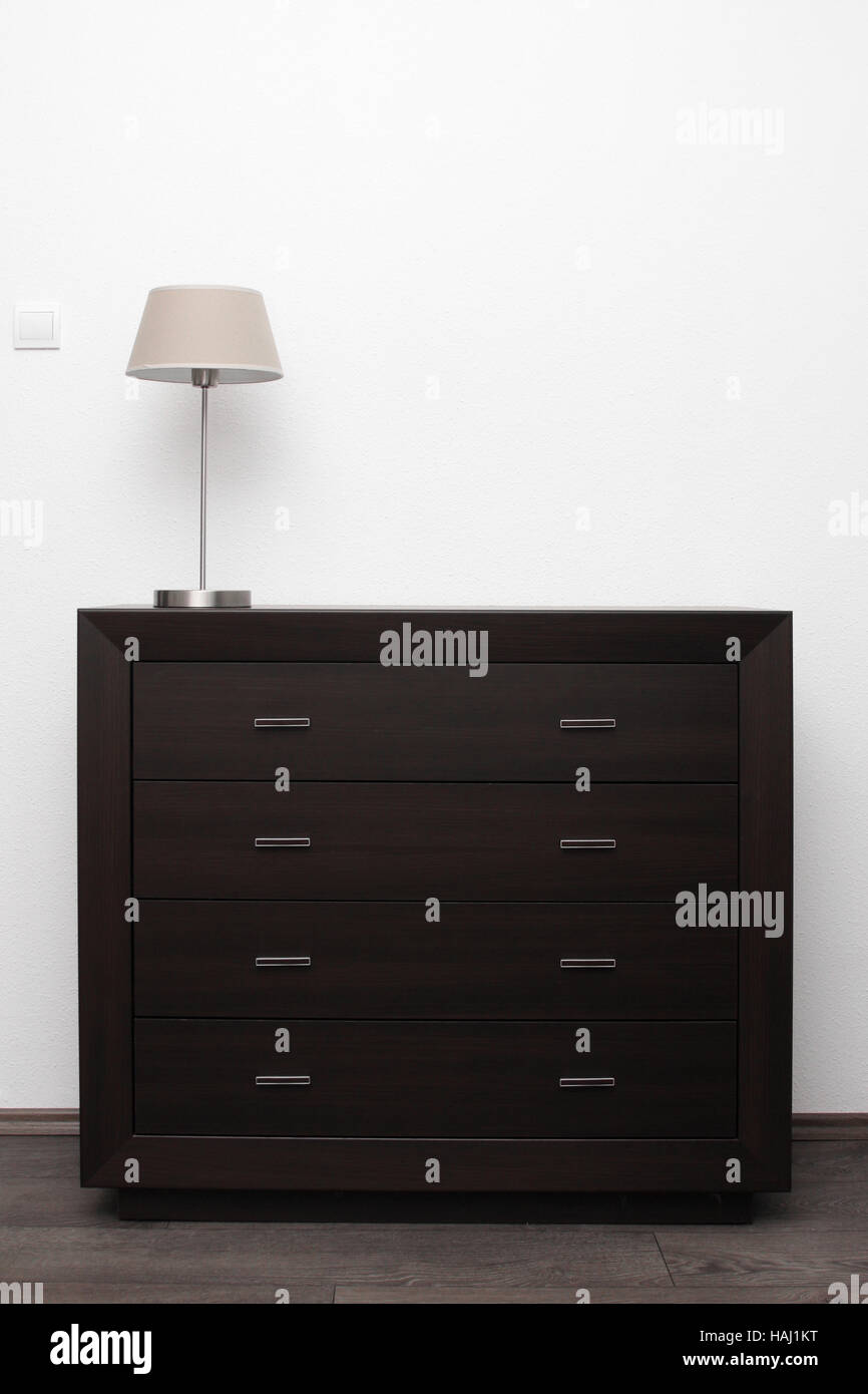 Commode marron avec lampe dans le minimalisme lumineux intérieur Banque D'Images Commode marron avec lampe dans le minimalisme lumineux intérieur Banque D'Images