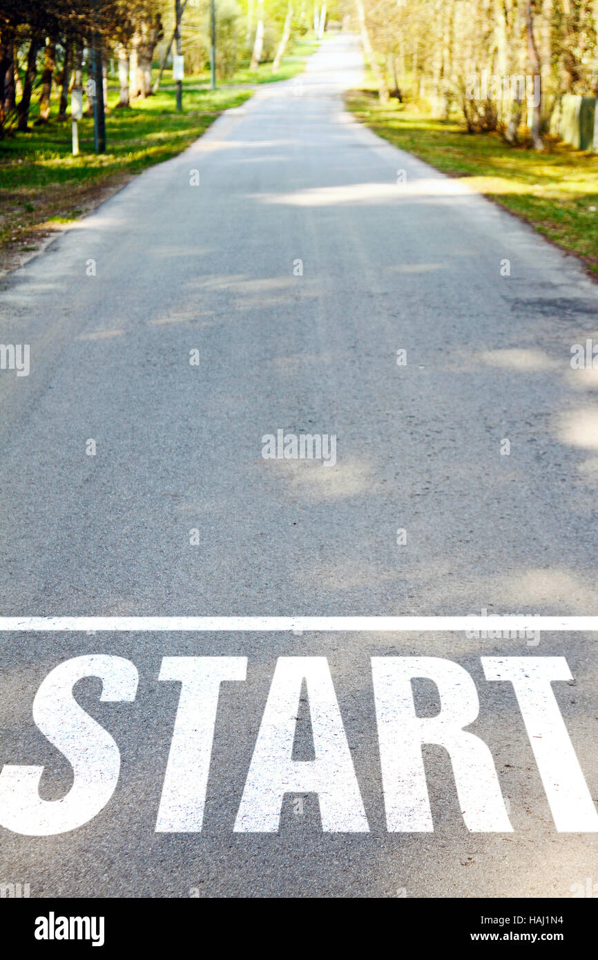 Route asphaltée avec blanc signe de début Banque D'Images