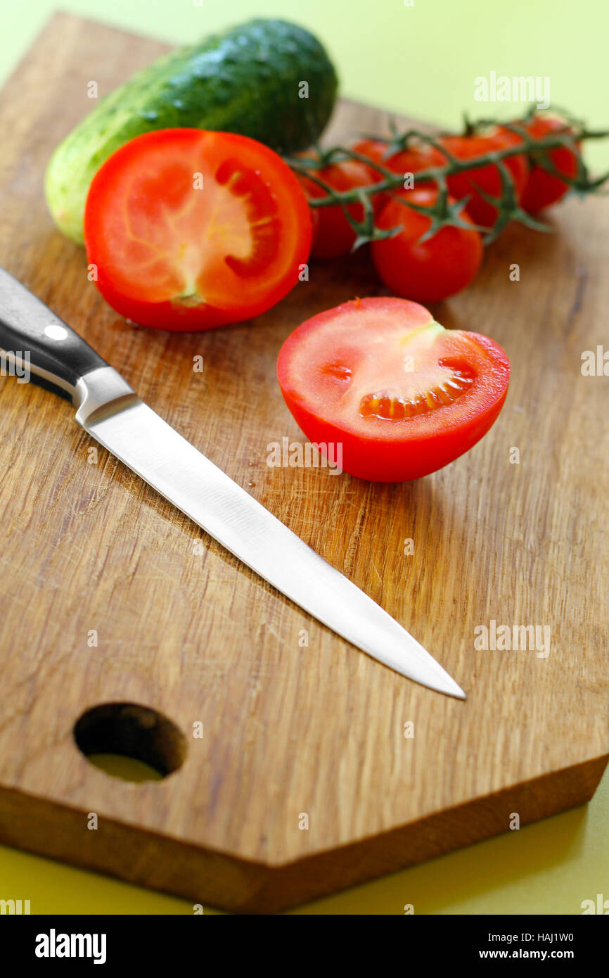 Les légumes et le couteau sur la planche à découper en bois Banque D'Images