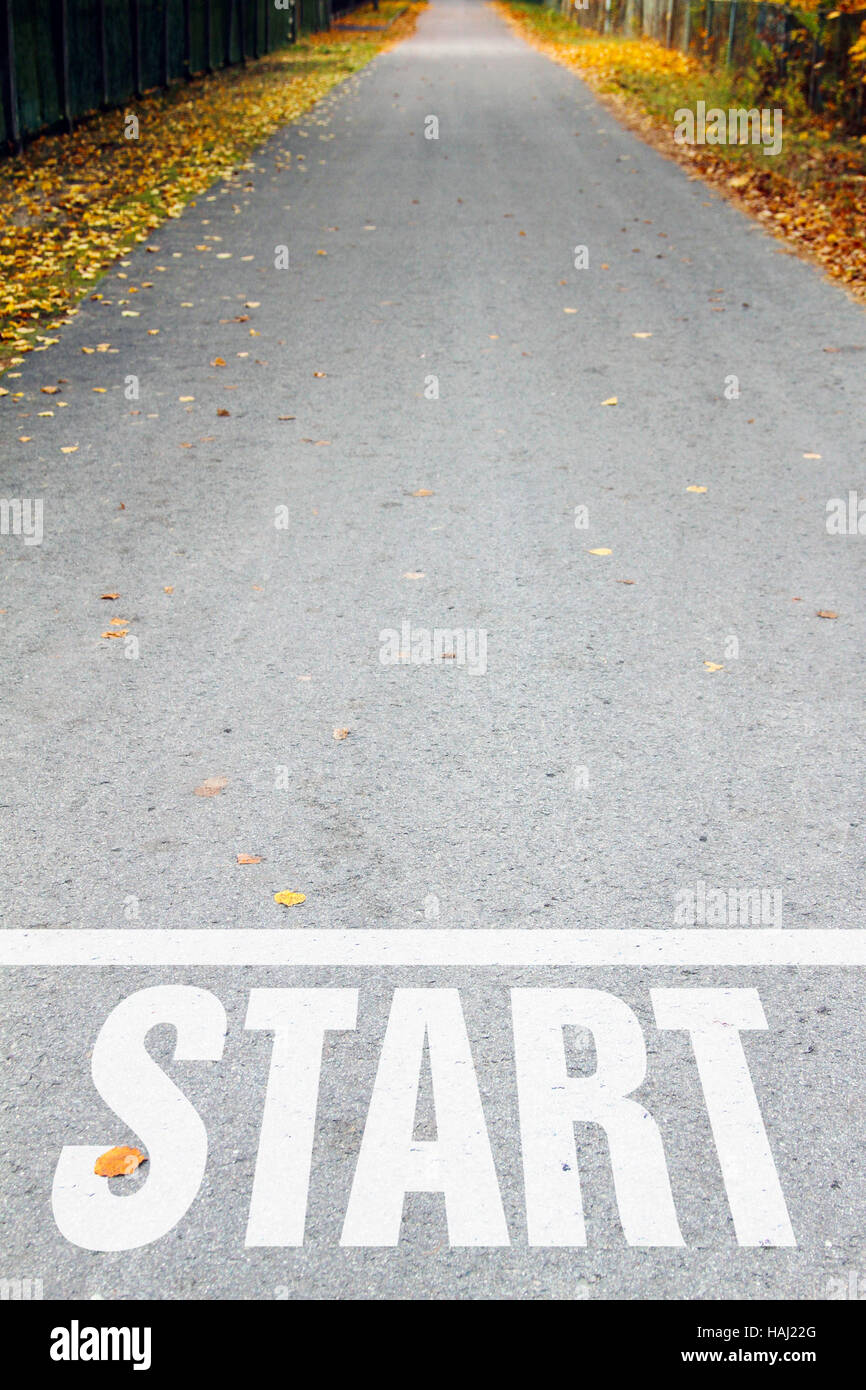 Route asphaltée avec blanc signe de début Banque D'Images