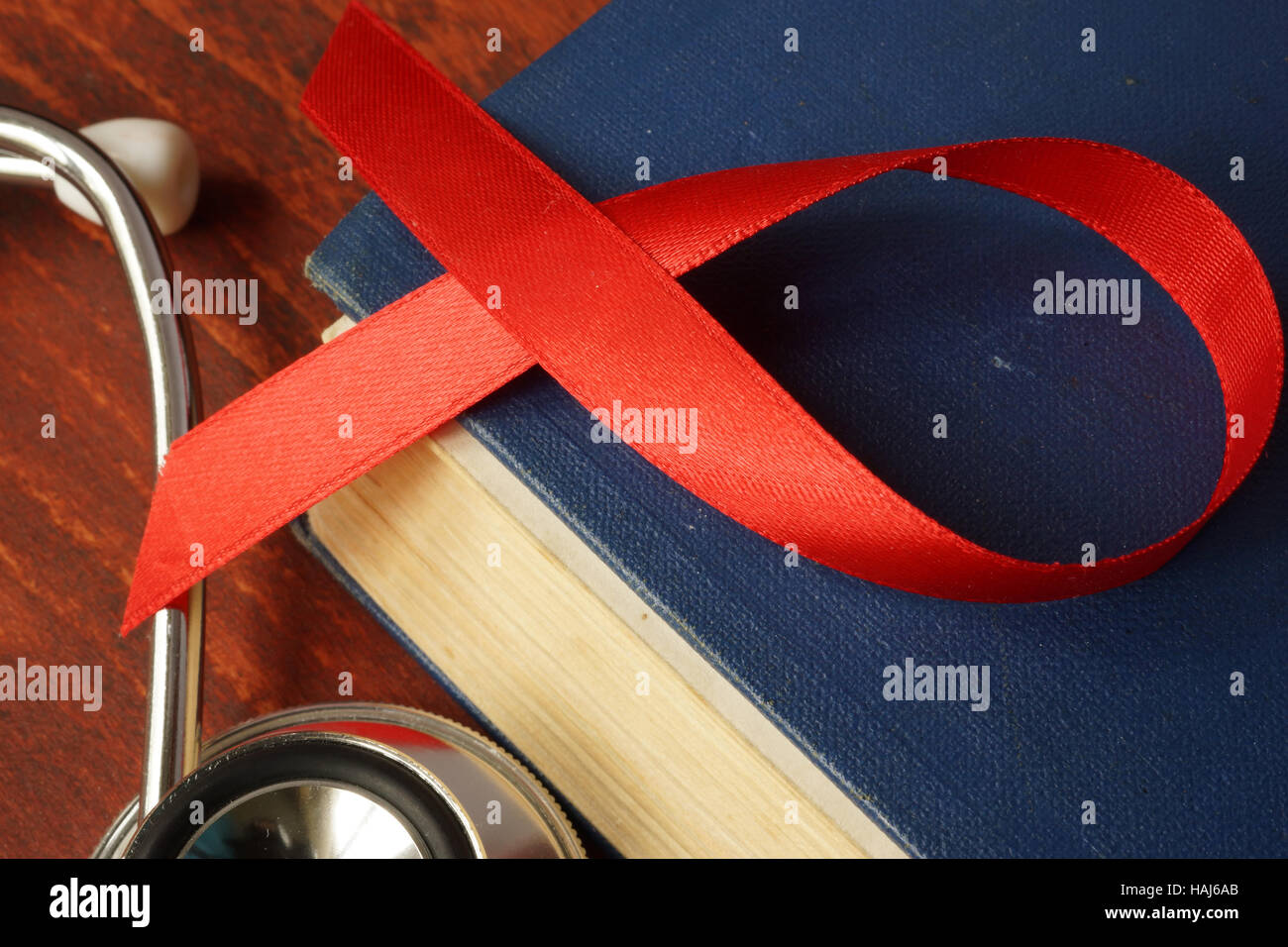 Le diagnostic de VIH/SIDA. Ruban rouge de sensibilisation sur un livre. Banque D'Images