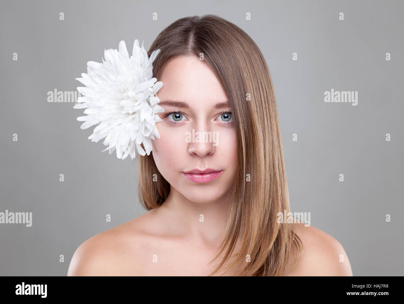 Belle brune femme avec une fleur blanche dans les cheveux Banque D'Images