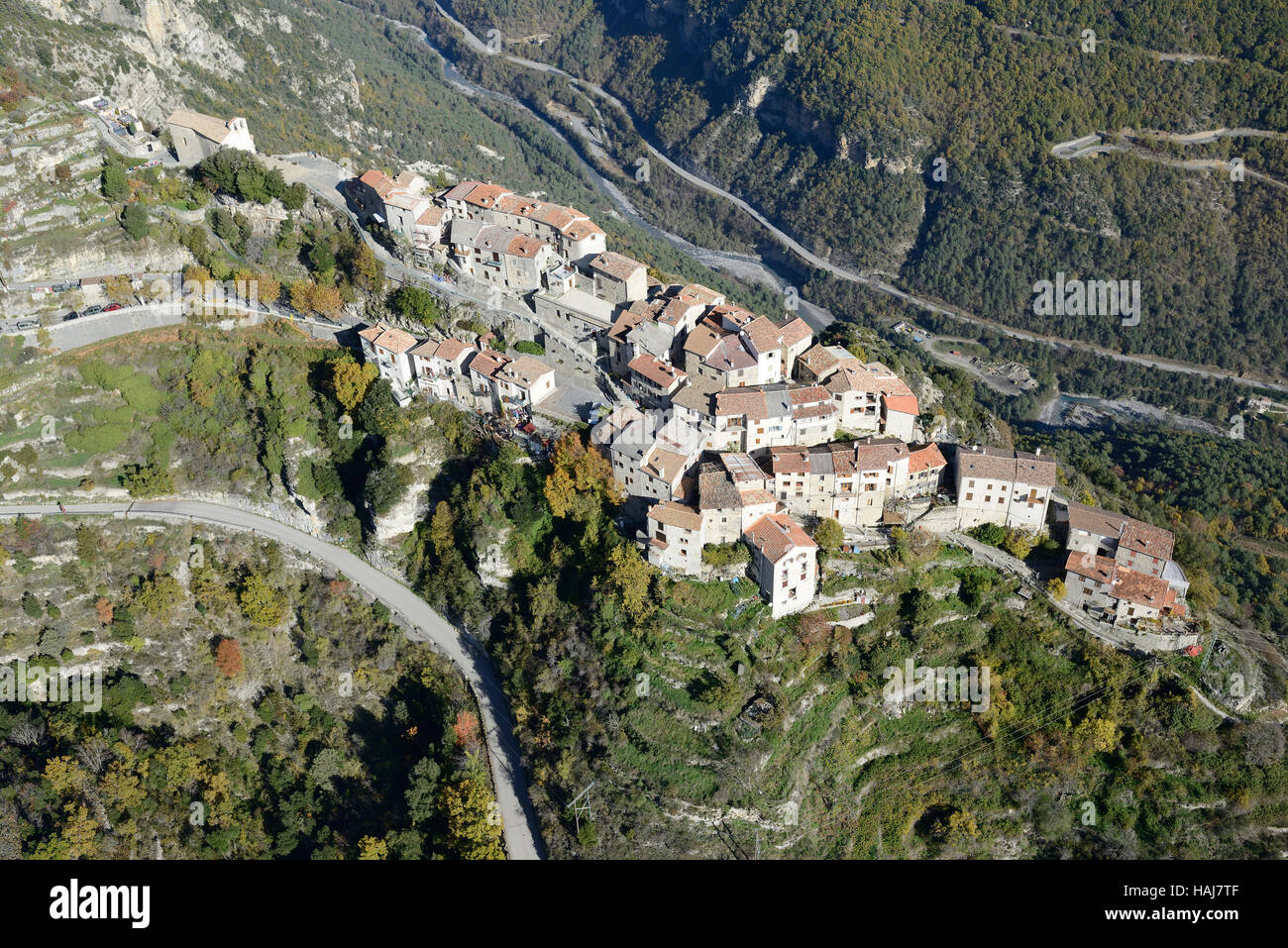 VUE AÉRIENNE. Village médiéval perché sur une étroite crête de calcaire au-dessus de la vallée de la Tinée. Bairols, Alpes-Maritimes, France. Banque D'Images