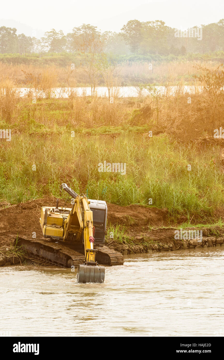 Godet de pelle sur les bords de la rivière , de soulever des charges, machines de construction, machines de construction, manipulateur, décharger des cargaisons des camions de ferme, capture hydraulique e Banque D'Images