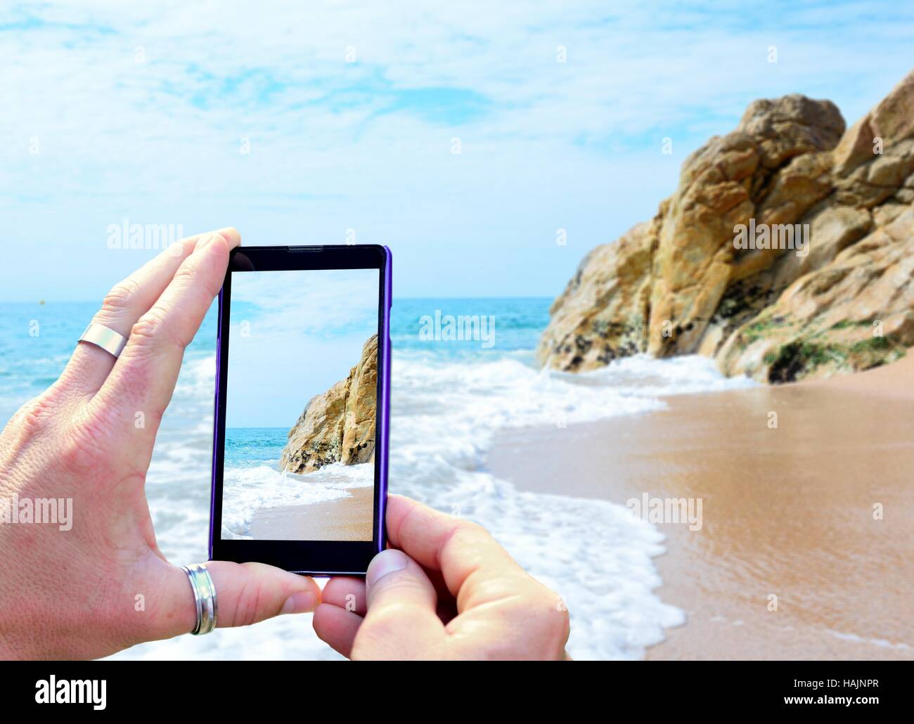 Vue sur l'écran du téléphone lors de la prise d'une photo de plage de Calella Costa Brava, Espagne. Maintenant le téléphone mobile dans les mains et prendre une phot Banque D'Images