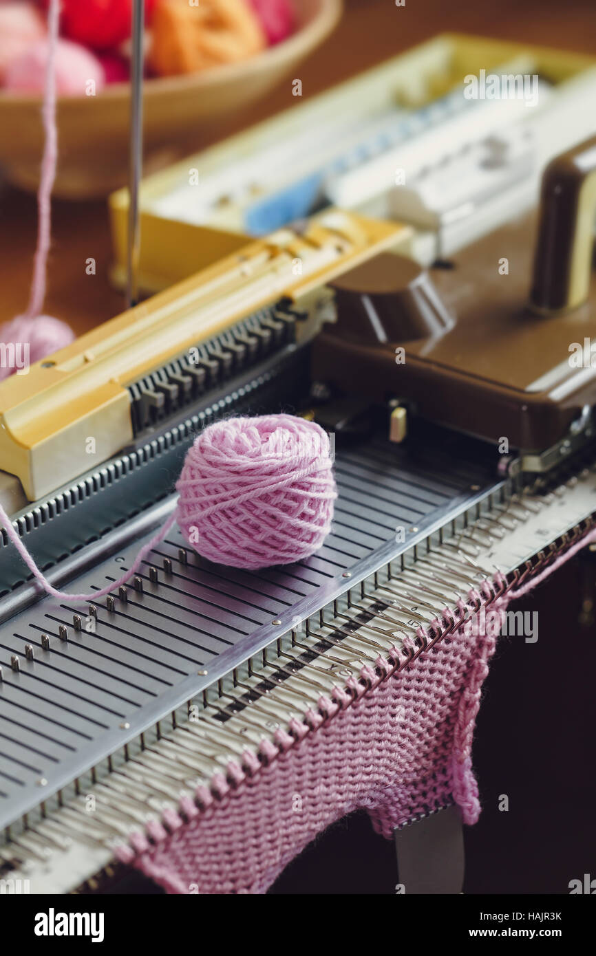 Machine à tricoter à la main. Une machine à tricoter est un dispositif utilisé pour créer les étoffes de bonneterie dans un semi ou entièrement automatisée. Banque D'Images