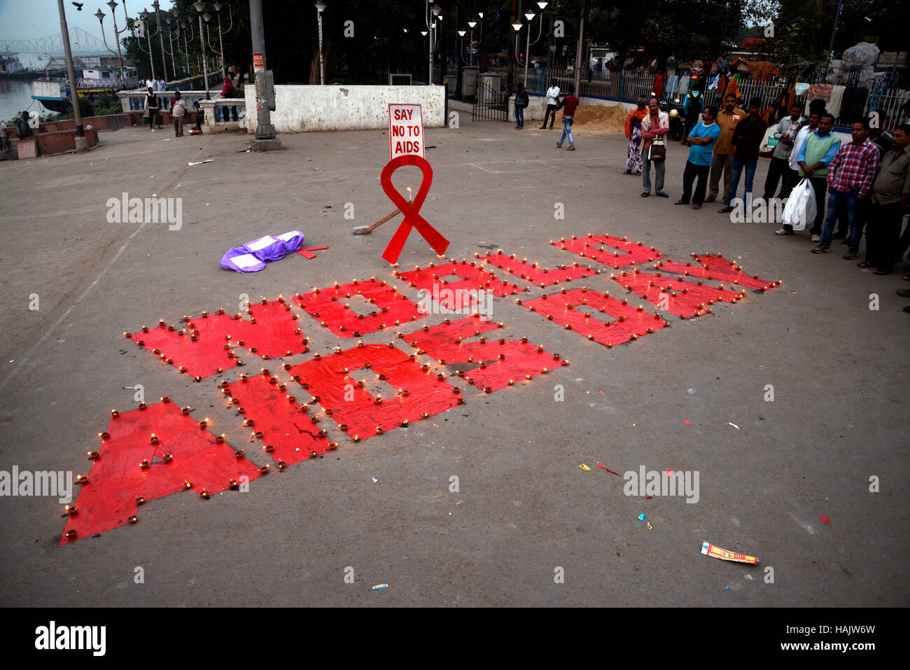 Kolkata, Inde. 06Th Dec 2016. Dessiner le symbole militant contre le sida et les lumières diya ou aussi lampe lanterne ciel libération pendant une campagne de sensibilisation sur la Journée mondiale de lutte contre le sida sur la banque du fleuve Ganga. La Journée mondiale du sida célébrée chaque année le 01 décembre pour sensibiliser sur le VIH/SIDA et de démontrer la solidarité internationale face à la pandémie. Credit : Saikat Paul/Pacific Press/Alamy Live News Banque D'Images