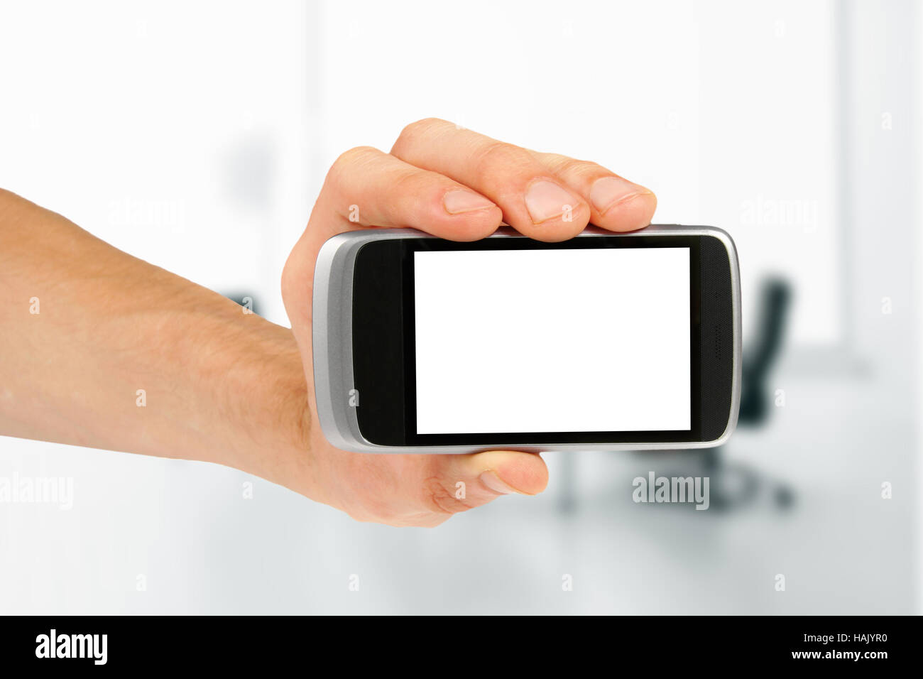 Hand holding blank téléphone intelligent au bureau Banque D'Images