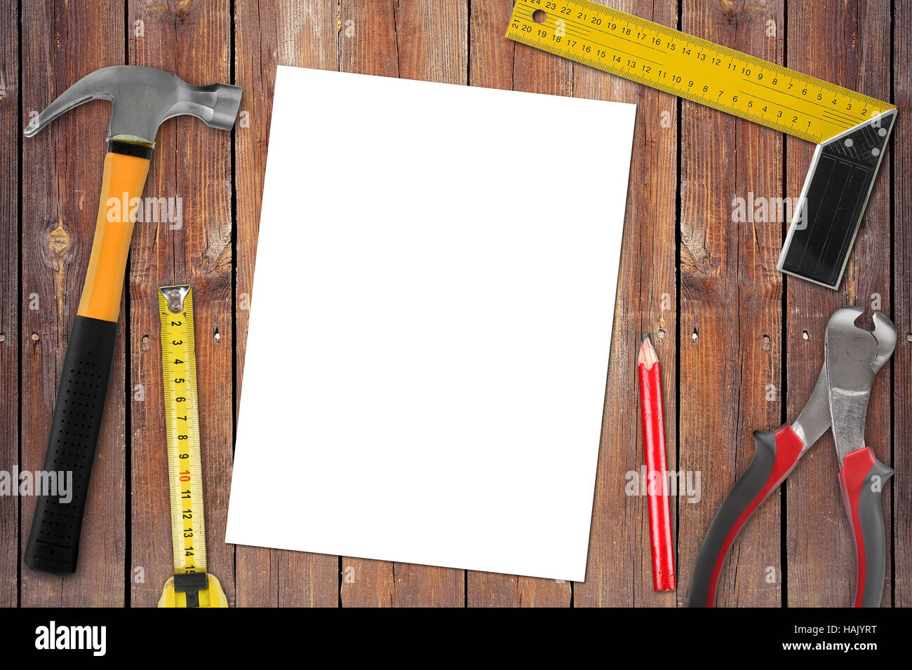 Page blanche avec des outils de travail sur fond de bois Banque D'Images