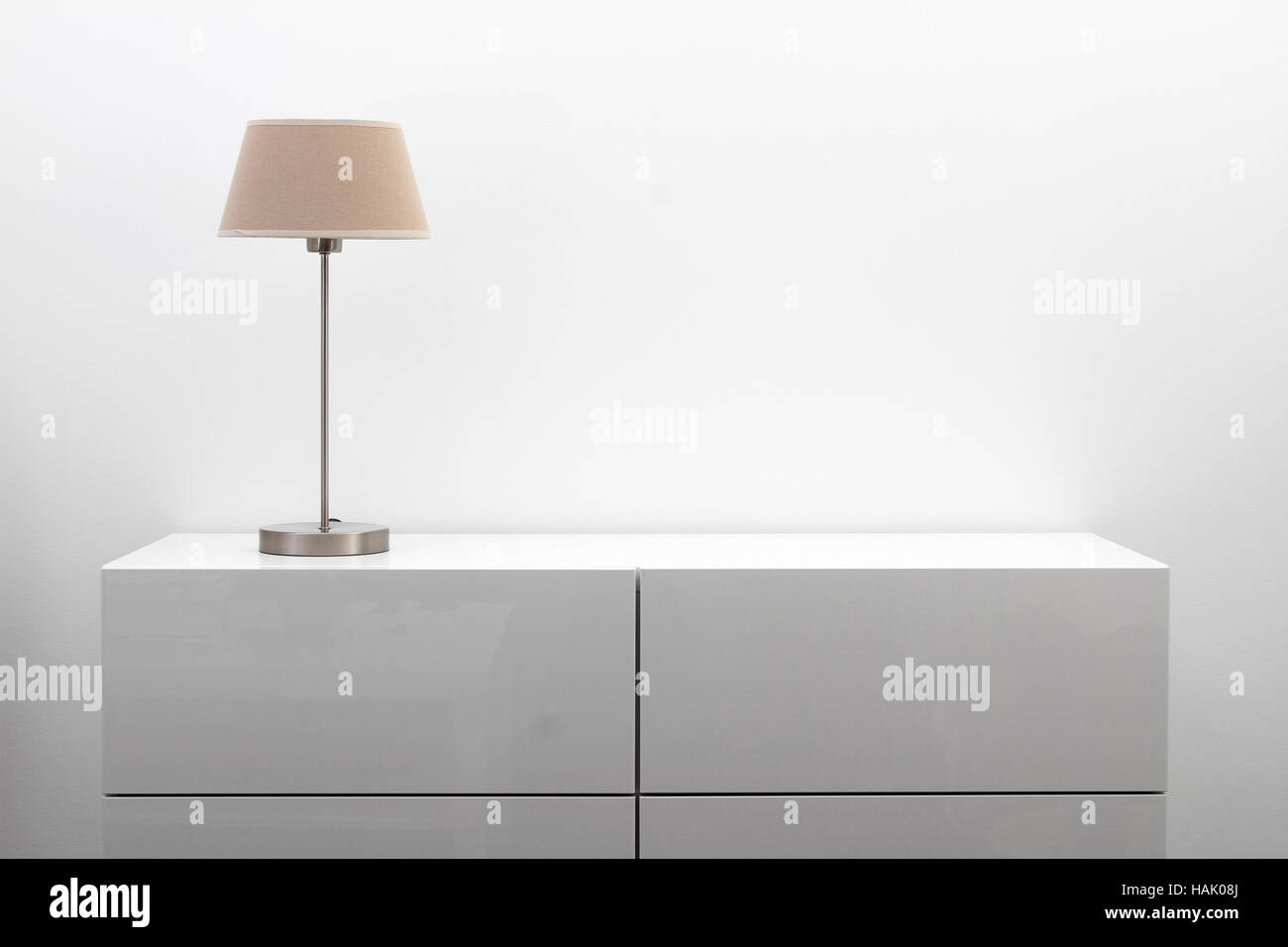 Commode blanche avec une lampe de table en intérieur le minimalisme lumineux Banque D'Images Commode blanche avec une lampe de table en intérieur le minimalisme lumineux Banque D'Images