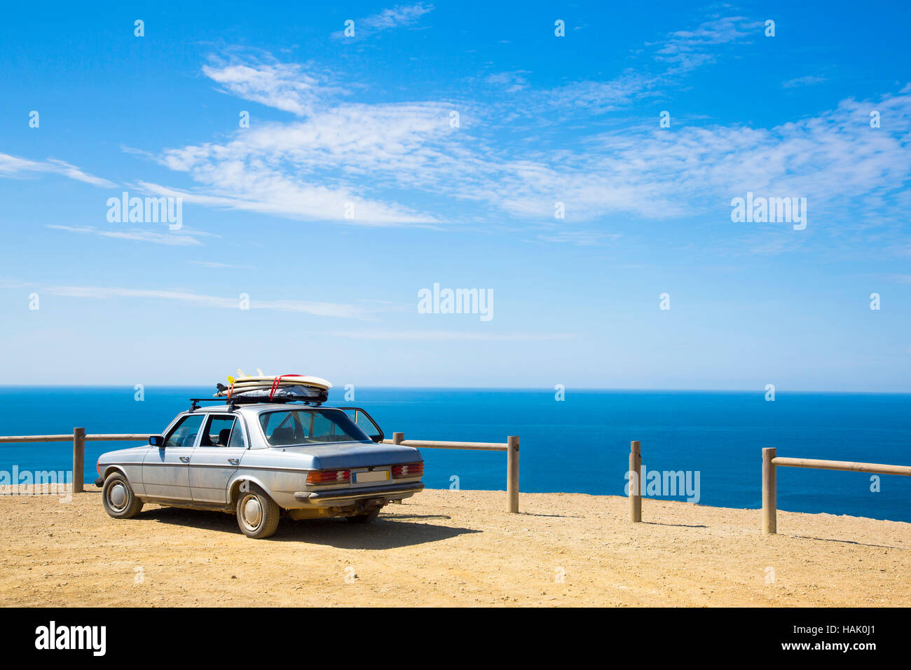 Vieille voiture rétro avec des planches sur le toit et de l'océan en arrière-plan Banque D'Images