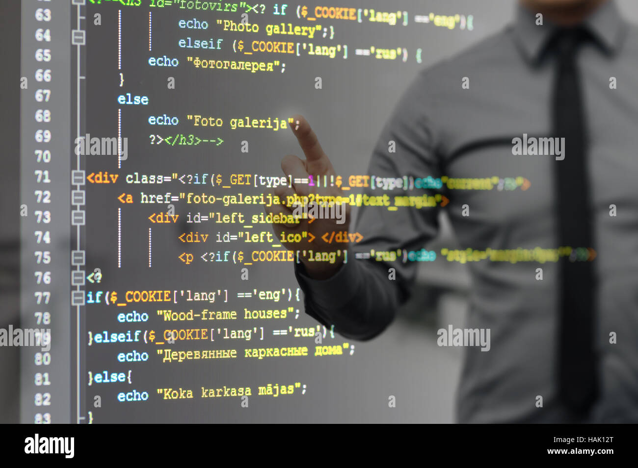 Homme pointant sur l'écran virtuel avec le code de programmation de site web Banque D'Images