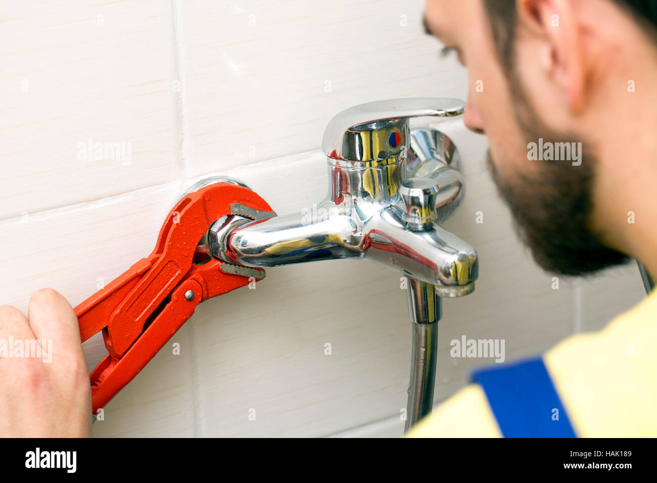 Plombier installation d'un robinet d'eau dans la salle de bains Banque D'Images