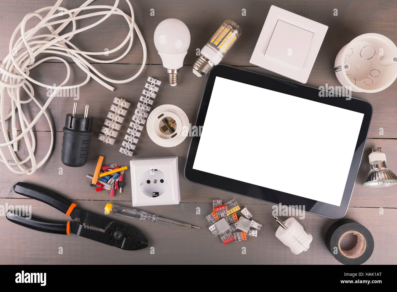 Tablette numérique vide avec des outils électriques et du matériel sur table en bois Banque D'Images
