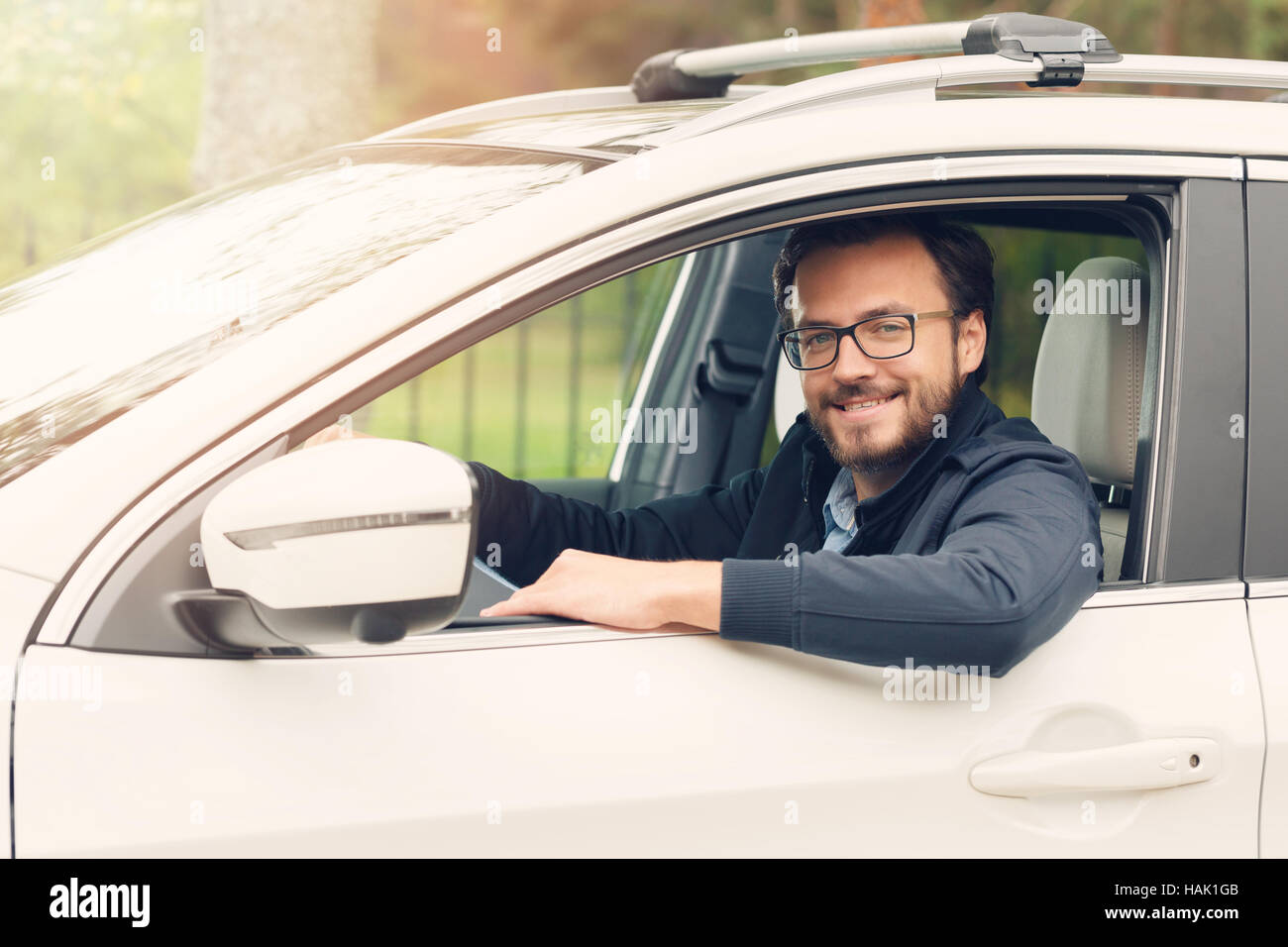 Heureux jeune homme assis dans la voiture Banque D'Images