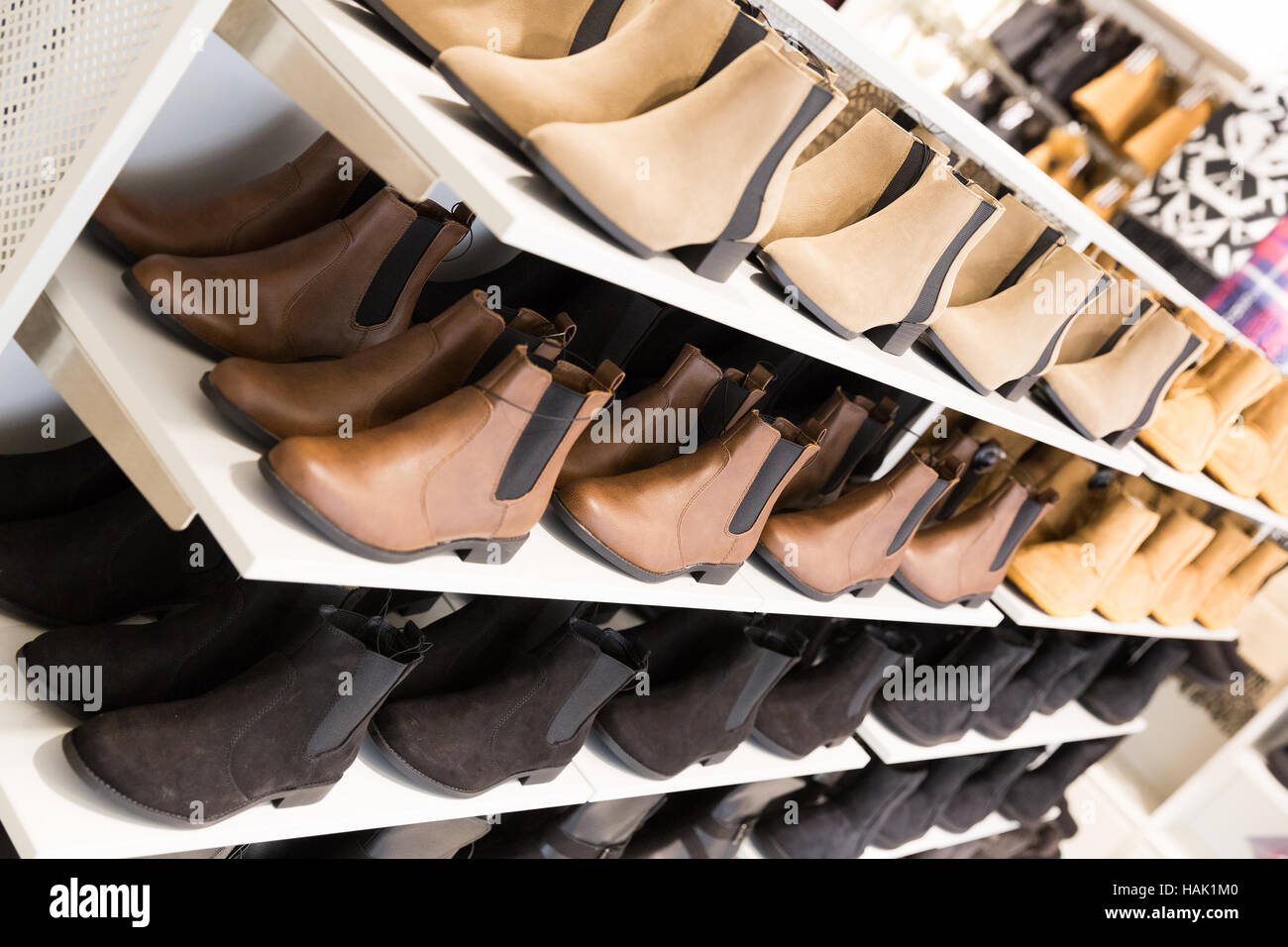 Les femmes avec des étagères dans un magasin de chaussures en cuir Banque D'Images