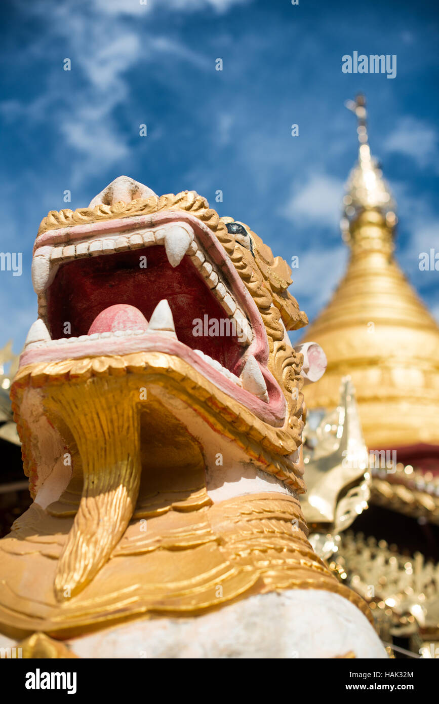 Chinthe Lion Statue Shwe Kyaung U Temple Bagan Myanmar // BAGAN, Myanmar — statues gardiennes de lion ornées connues sous le nom de stand de chinthe devant le stupa doré et architecture élaborée du temple Shwe Kyaung U . Le temple bouddhiste du XVIIIe siècle, documenté comme Monument 2007 dans l'inventaire architectural de Pierre Pichard, est situé dans un monastère au nord-est de Pagan près du village de Taungbi. Le temple présente une construction traditionnelle en maçonnerie de briques avec un pavillon en bois distinctif ajouté sur sa face ouest, reflétant les adaptations faites pour servir la communauté monastique résidente. Temple Shwe Kyaung U Re Banque D'Images