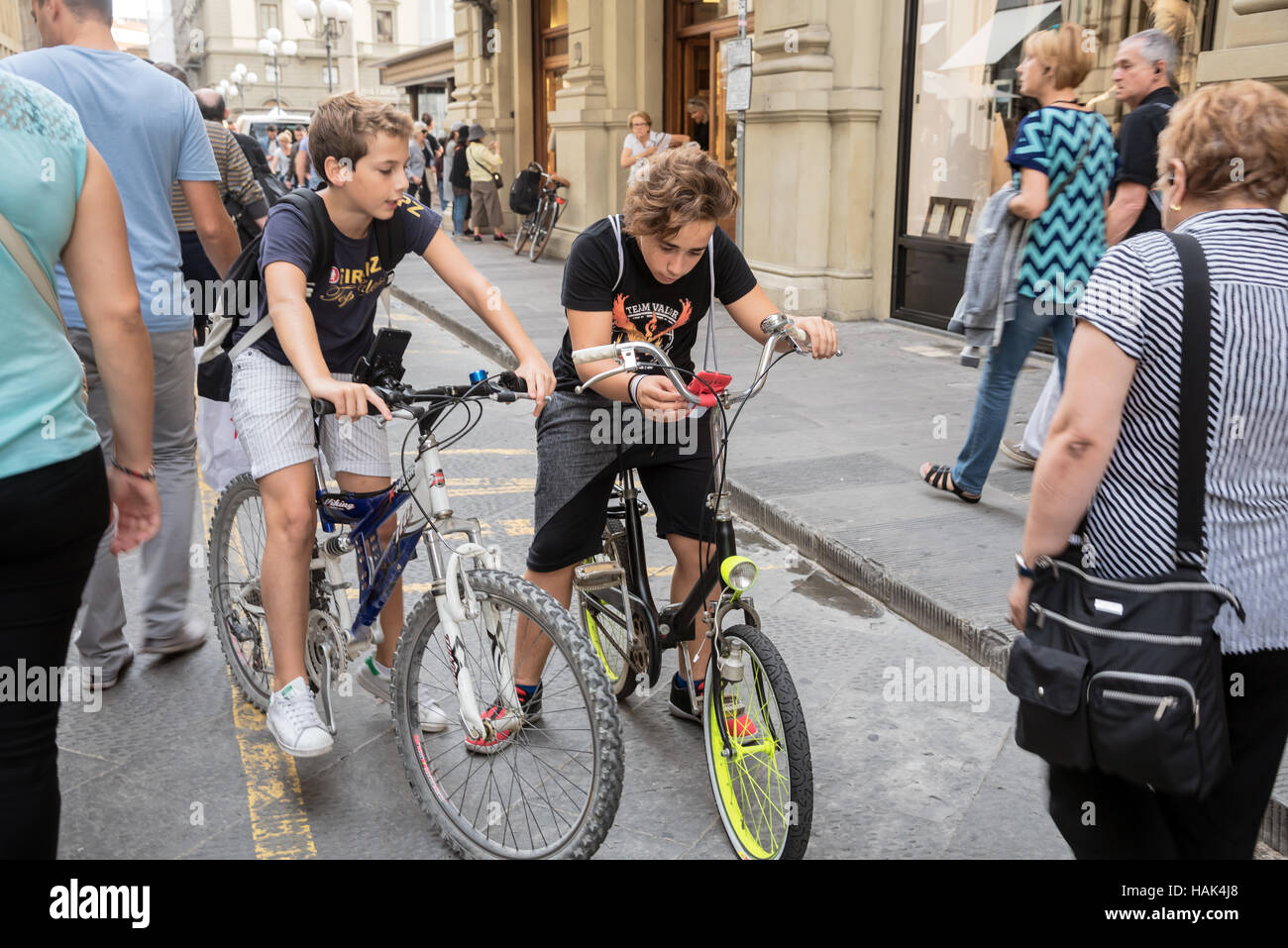 Scène de rue : deux garçons sur les vélos, Florence, capitale de la région Toscane, Italie Banque D'Images