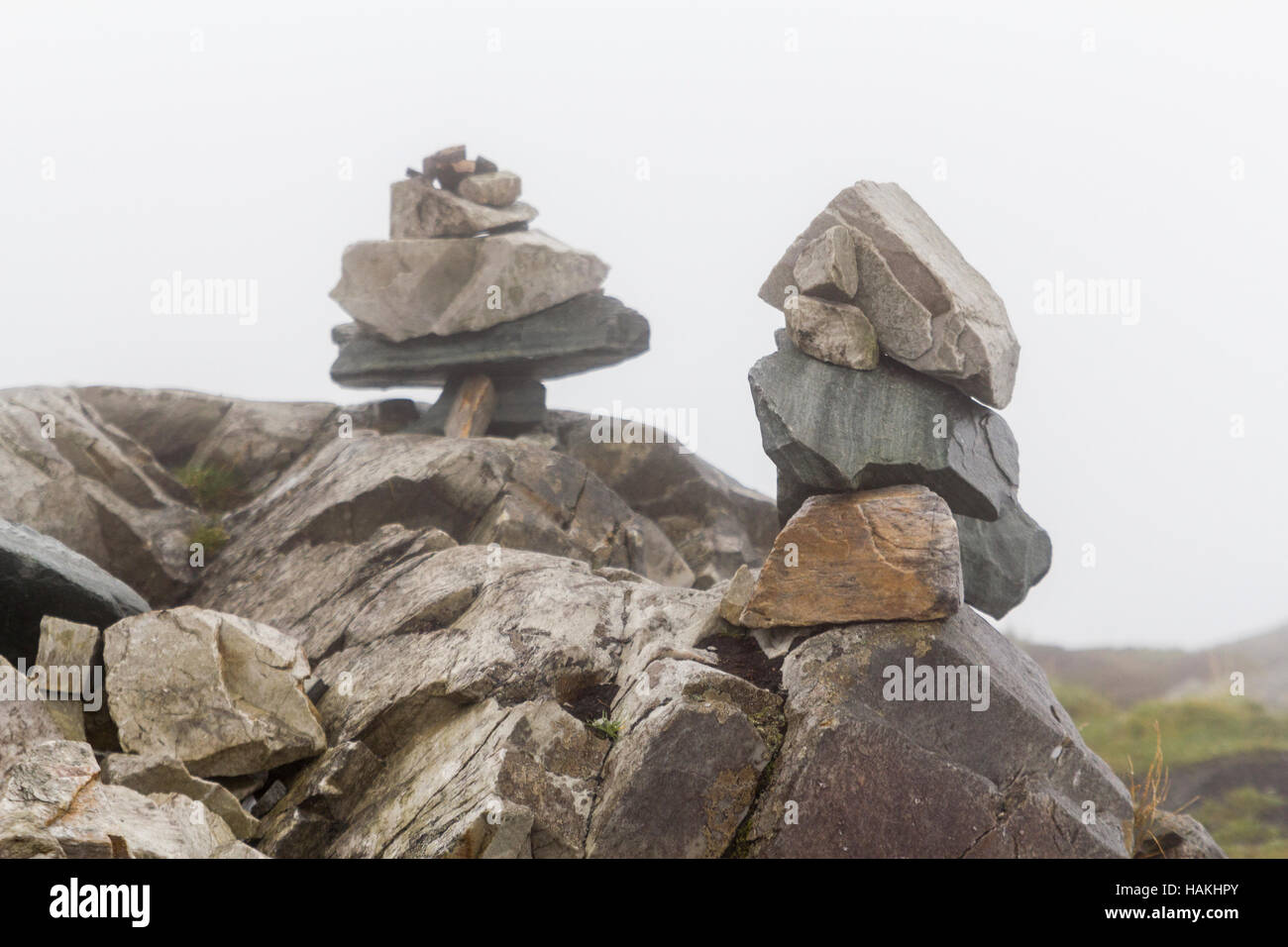 Pierres empilées ou cairn marque un sentier dans le brouillard. Banque D'Images