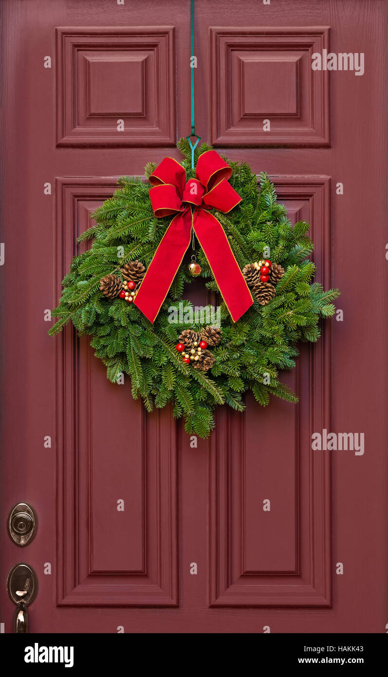 Couronne de Noël suspendu à une porte rouge Banque D'Images