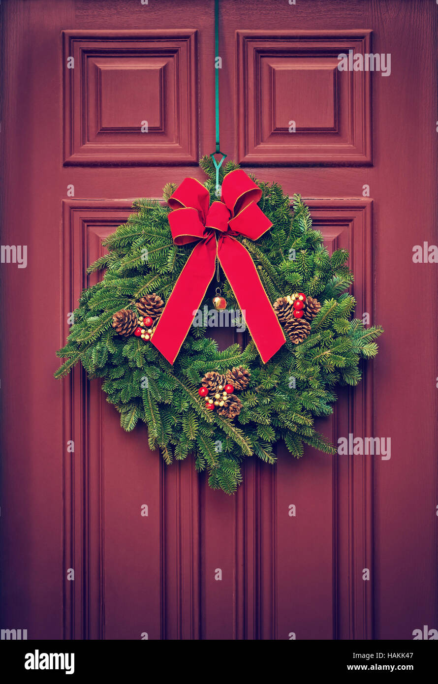 Couronne de Noël suspendu à une porte rouge Banque D'Images