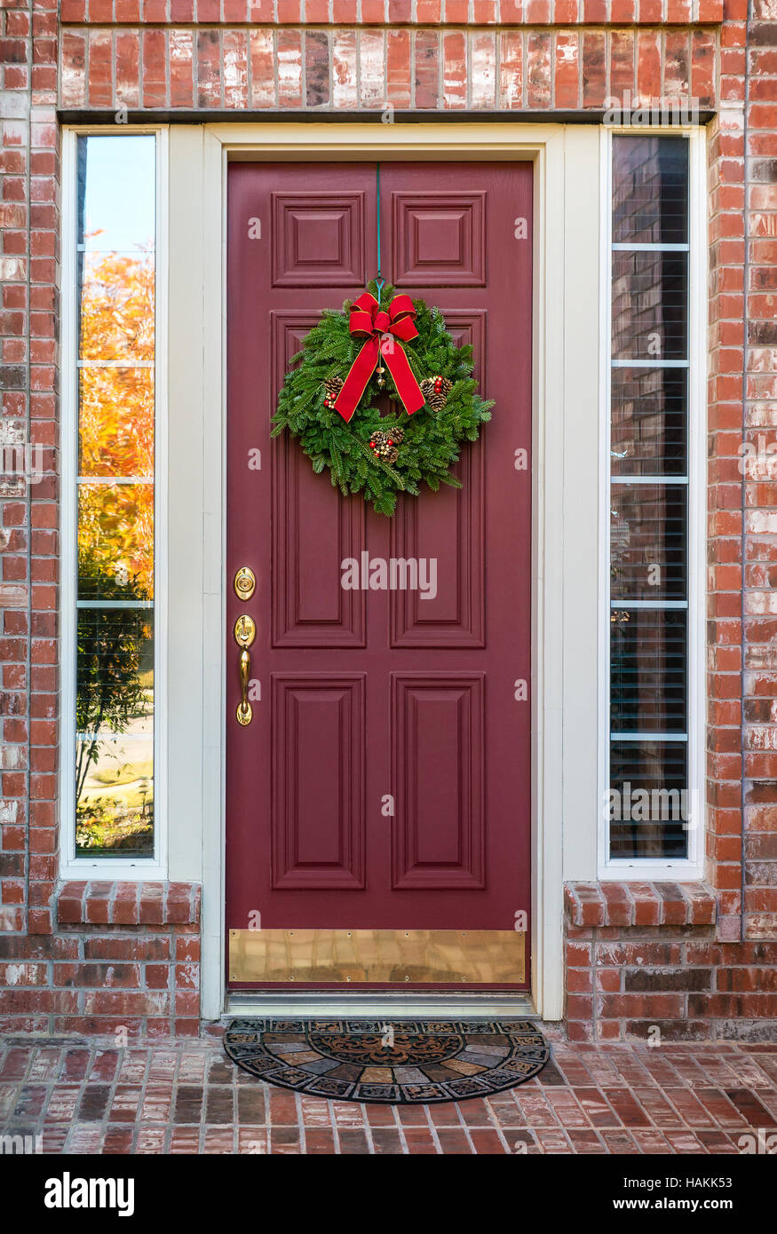 Couronne de Noël suspendu à une porte rouge Banque D'Images